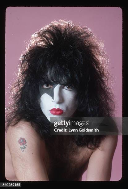 Head shot of musician Paul Stanley of the glam-rock band "Kiss" wearing his stage make-up with his hair teased out as far as possible. On his right...