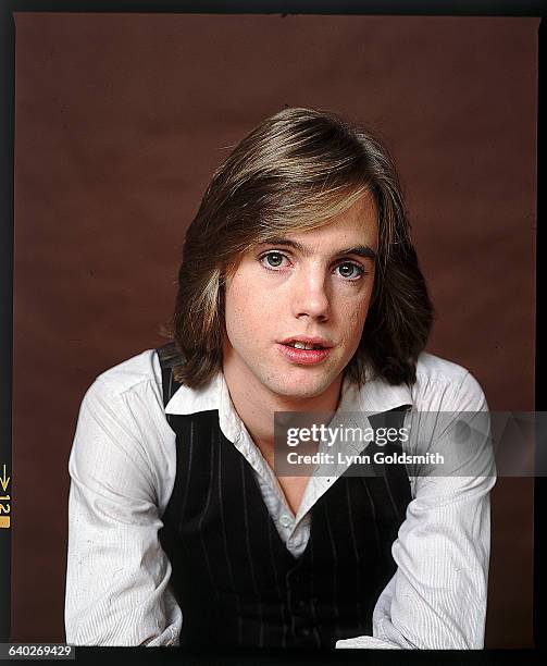 Picture shows a posed portrait of actor/singer Shaun Cassidy. He is leaning foward on his arms and wearing a white buttondown and a pin-striped vest.