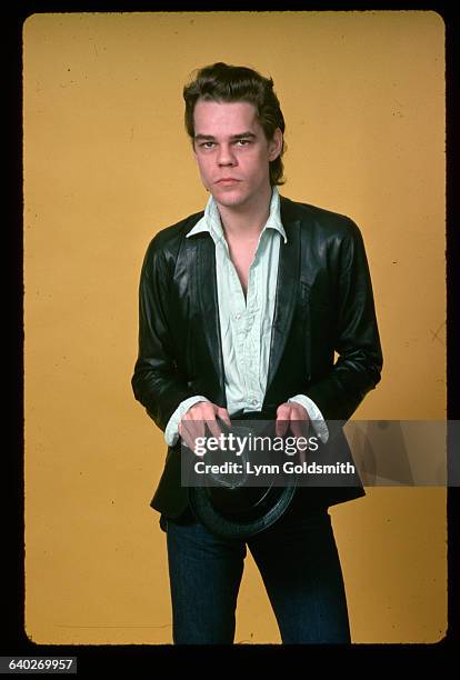 Studio portrait of actor/musician David Johansen . He is shown in a 3/4-length view, holding a leather hat. Undated photograph.