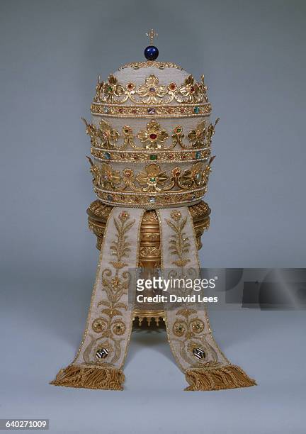 The papal tiara is a stack of three crowns that represent the Holy Trinity. As with all papal headdresses it is surmounted by a cross, this one of...