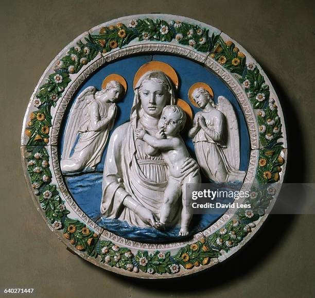 Piece depicting the Virgin Mary with the infant Jesus flanked by angels, by the Florentine sculptor Luca della Robbia . This work is titled 'Virgin...