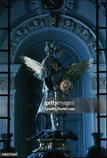 An elaborately clothed statue of Saint Michael. He stands upon the black figure of Satan driving his sword into the devil's back.