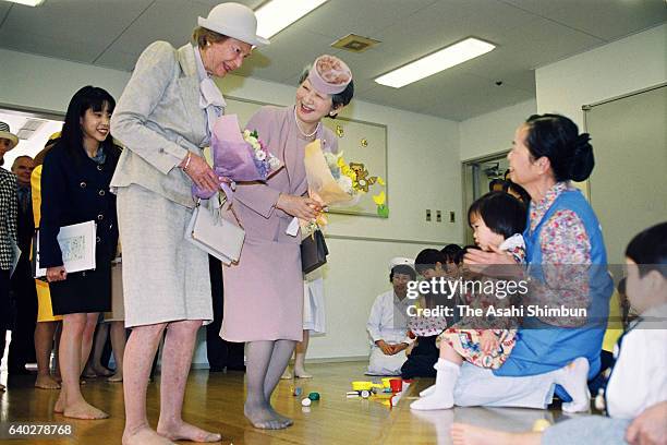 Grand Duchess Josephine Charlotte of Luxembourg and Empress Michiko visit the Home for Infants of the Japan Red Cross Medical Center on April 7, 1999...