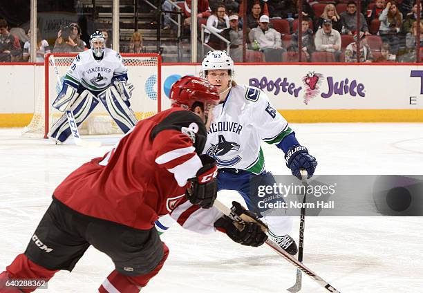 Philip Larsen of the Vancouver Canucks backs into his own zone while defending Tobias Rieder of the Arizona Coyotes at Gila River Arena on January...