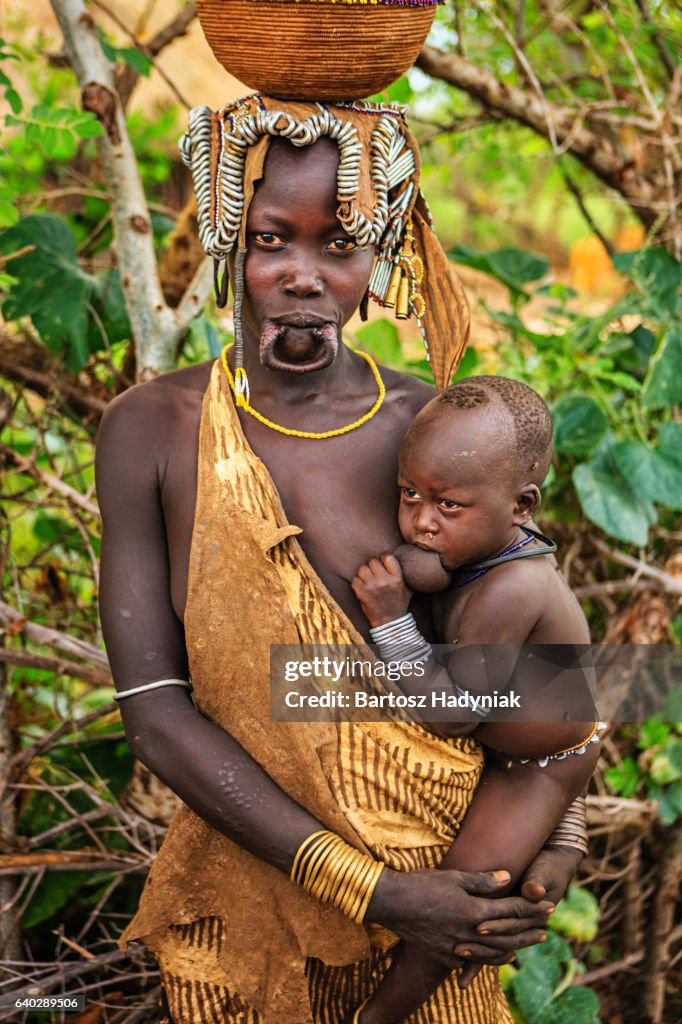 Woman from Mursi tribe breasfeeding her baby, Ethiopia, Africa