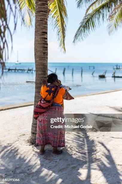 woman in traditional clothing talking on a cell phone - ambergris caye stock pictures, royalty-free photos & images