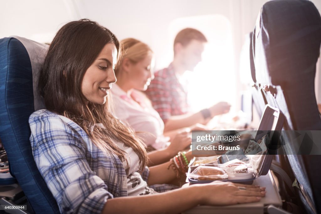 Passengers having lunch while traveling by airplane.