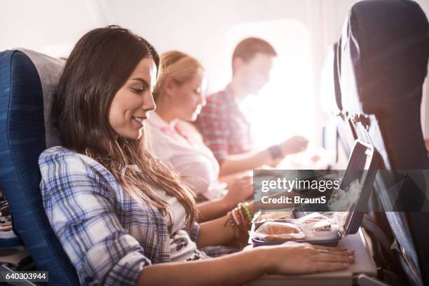 passengers having lunch while traveling by airplane. - flight food stock pictures, royalty-free photos & images