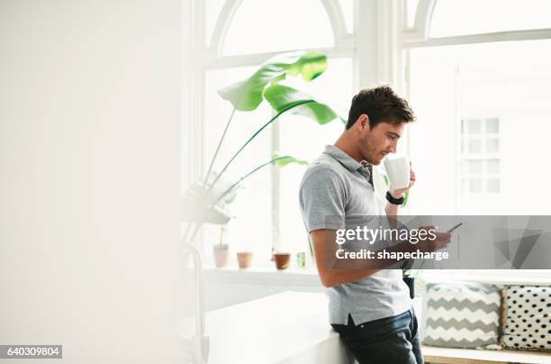 catching up on social media over his morning coffee - coffee at home imagens e fotografias de stock