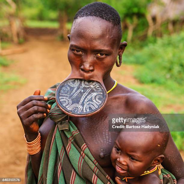 mulher da tribo mursi breasfeeding seu bebê, etiópia, áfrica - cultura tribal africana - fotografias e filmes do acervo