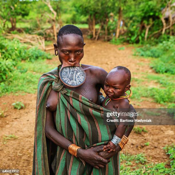 woman from mursi tribe breasfeeding her baby, ethiopia, africa - african tribal culture 個照片及圖片檔
