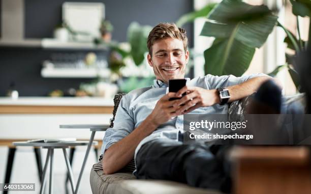 her messages always make him smile - man holding phone imagens e fotografias de stock