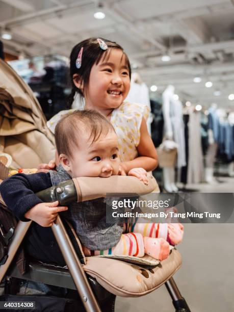 lovely little girl playing with her baby sister in a fashion boutique. - chinese baby shoe stock pictures, royalty-free photos & images