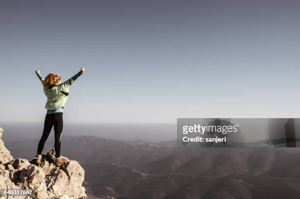 female hiker with raised arms on top of the hill - topwoman stock pictures, royalty-free photos & images