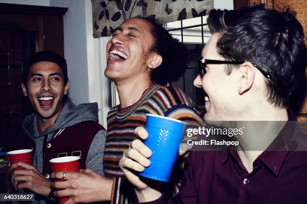 group of friends having fun at a party - drinking alcohol at home photos et images de collection