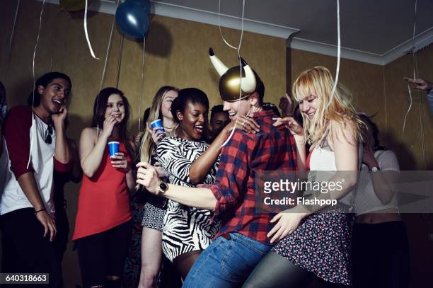 group of friends having fun at a party - viking helmet stock-fotos und bilder