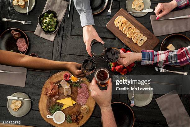 overhead view of friends sharing a meal - beer and food bildbanksfoton och bilder