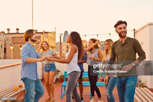 happy friends dancing at the rooftop party - izabela habur stock pictures, royalty-free photos & images