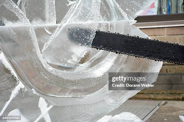 making a ice sculpture with chainsaw - ice sculpture stock-fotos und bilder