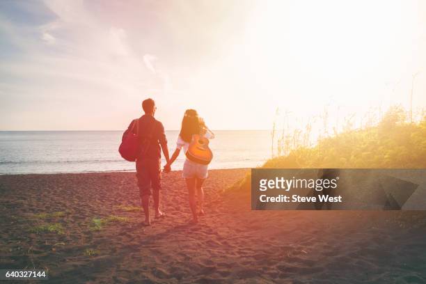 couple walking on the beach at sunset - japanese couple beach stock pictures, royalty-free photos & images