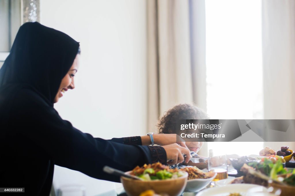 Family gathering, three generations eating traditional food.