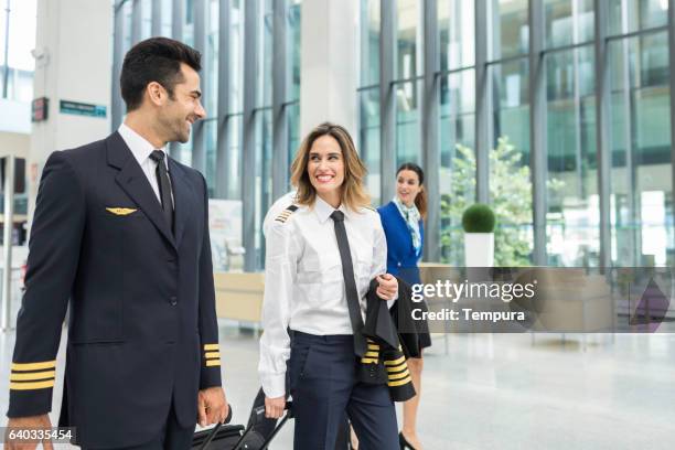 cabin crew walking through the airport. - pilot stock pictures, royalty-free photos & images