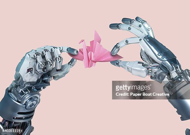 robot hand making an origami paper crane - robot stock pictures, royalty-free photos & images