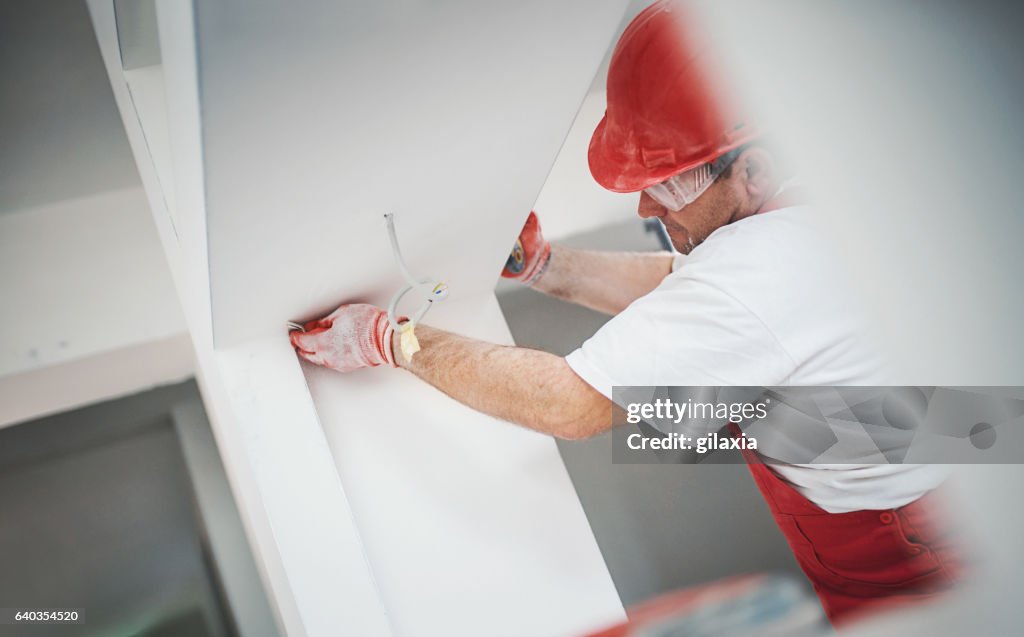 Construction worker finishing a drywall.