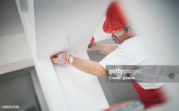 construction worker finishing a drywall. - beëindigen stockfoto's en -beelden