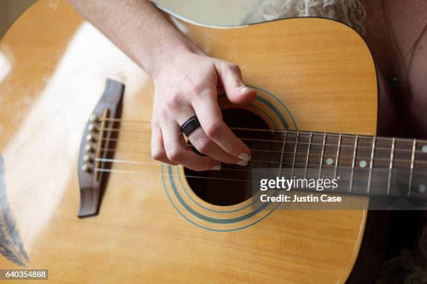 hand of a woman strumming the guitar - acoustic guitar foto e immagini stock