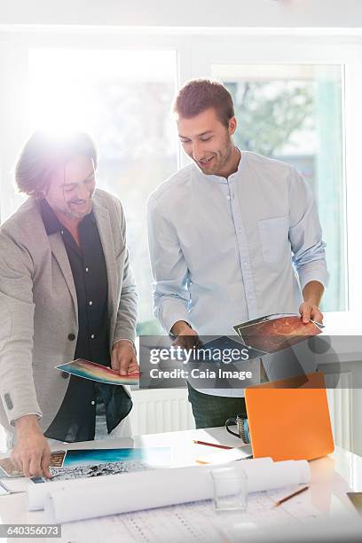 creative businessmen reviewing photography proofs in office - future proof stock-fotos und bilder