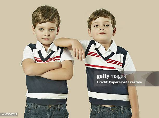 identical twins standing next to each other - twin males stock pictures, royalty-free photos & images