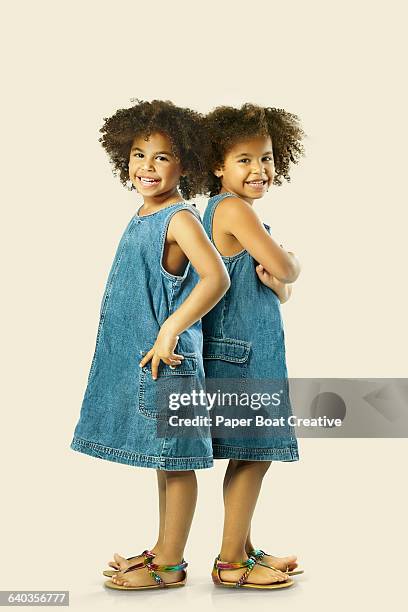 two identical twin sisters holding hands together - twin girls bildbanksfoton och bilder