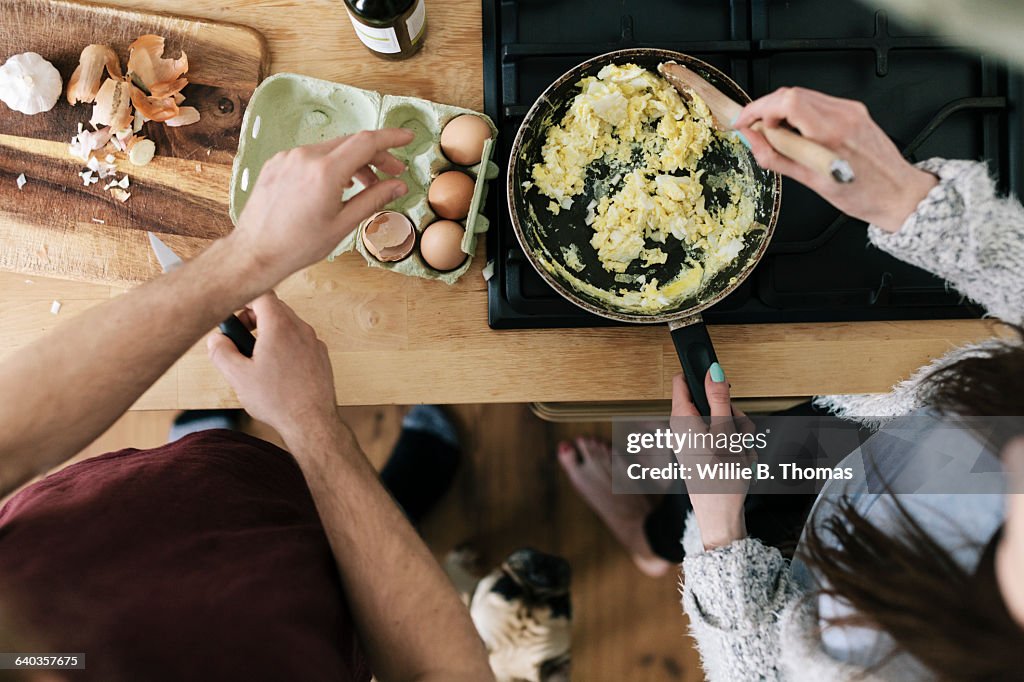 Overhead view of couple making eggs
