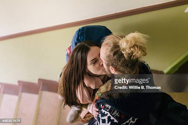 backpackers kissing on staircase - backpacker apartment stock-fotos und bilder