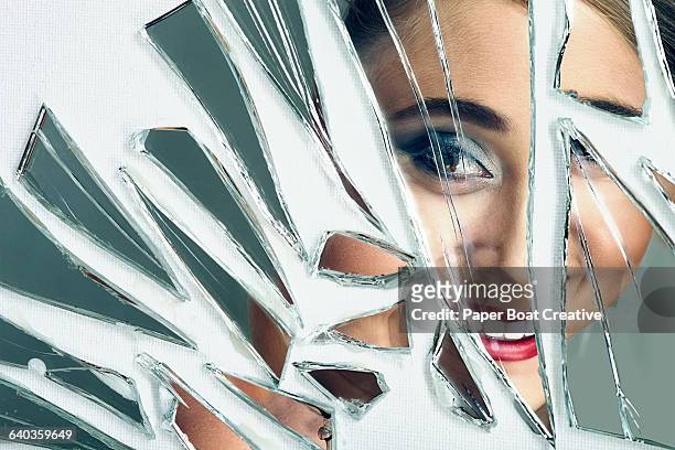young pretty lady smiling in to a broken mirror - broken glass pieces stock pictures, royalty-free photos & images
