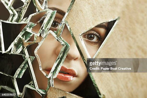 close up of a woman looking through broken glass - 割れガラス ストックフォトと画像