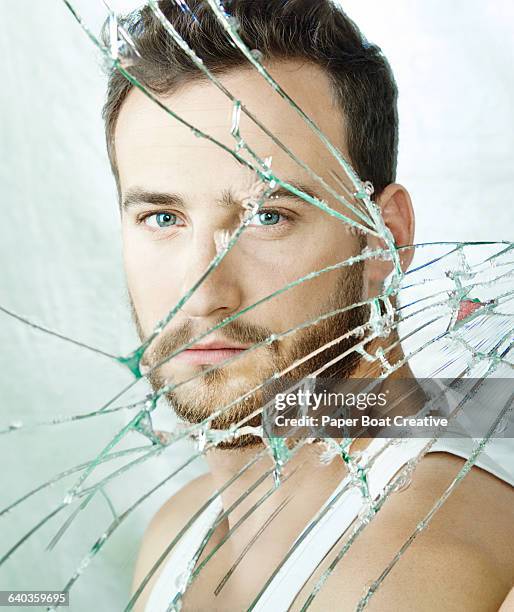 clean portrait of a young man in a broken mirror - broken mirror stock-fotos und bilder