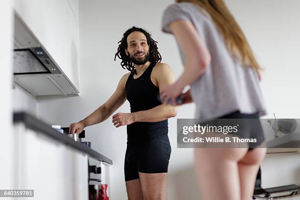 interracial couple in kitchen making coffee - damesonderbroek stockfoto's en -beelden