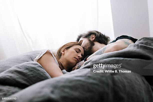 couple sleeping in bed together - descansar imagens e fotografias de stock