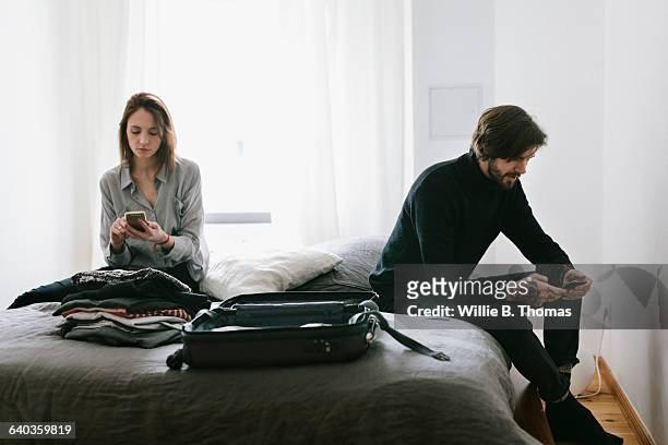 couple with unpacked suitcase - aufteilung stock-fotos und bilder