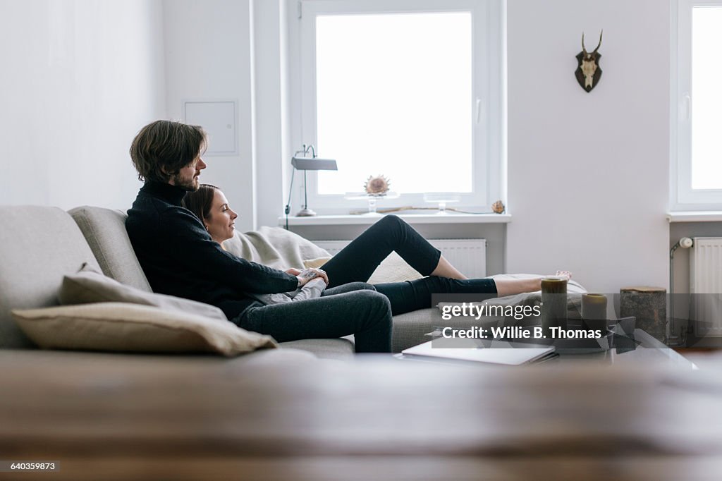 Couple snuggling on couch