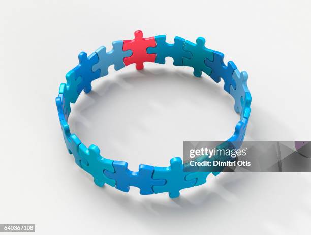 circle of blue puzzle pieces, one red - 3d puzzle stock-fotos und bilder