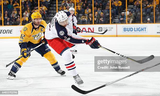 Seth Jones of the Columbus Blue Jackets shoots the puck against Mike Fisher of the Nashville Predators during an NHL game at Bridgestone Arena on...