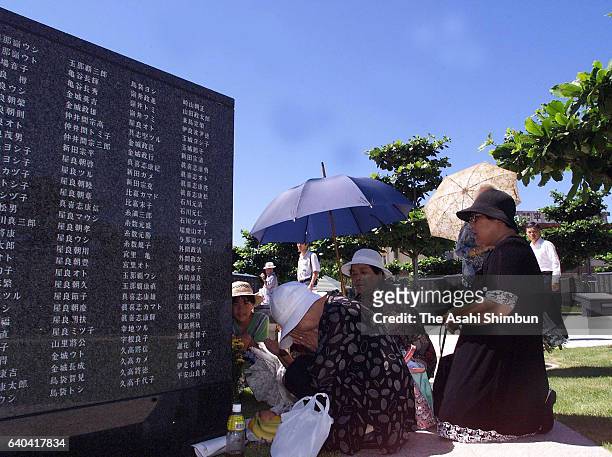 Women pray for the victims at the Cornerstone of Peace memorial at the 'Mabuni-no-oka', in Peace Memorial Park as Japan marks the 54th anniversary of...