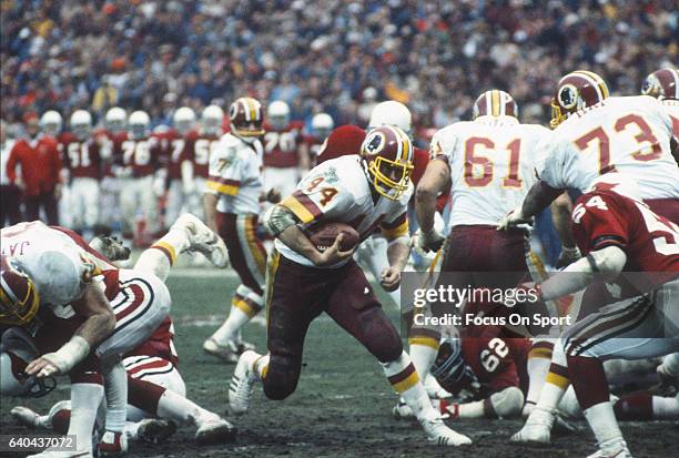 Washington, D.C. Running back John Riggins of the Washington Redskins carries the ball against the St. Louis Cardinals during an NFL football game...