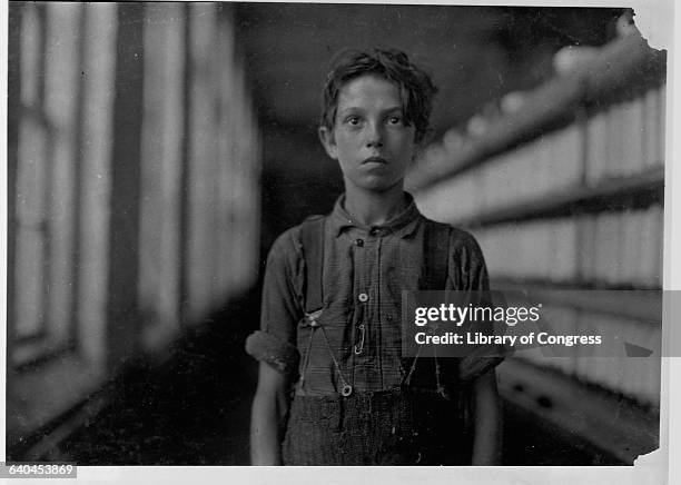 Jo Hudson, a "back-roper," stands next to a machine that dispenses thread, in the "mule room" at the Chace Cotton Mill in Burlington, Vermont.