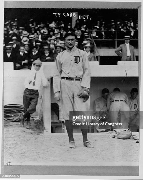 Portrait of Ty Cobb in front of a dugout during a game.