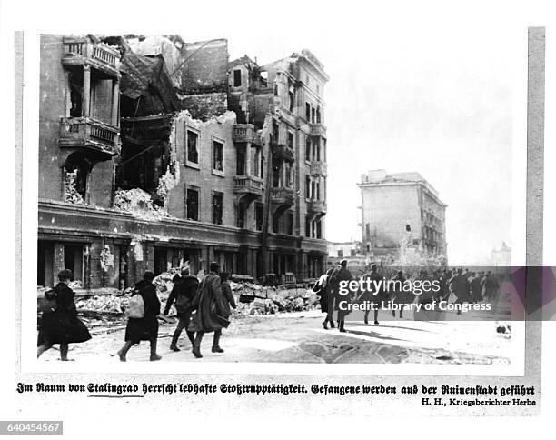 Prisoners walk past derelict and decrepit buildings, on their way out of Stalingrad. During World War II.