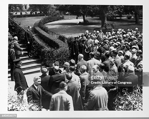 President Calvin Coolidge speaks to a group of people gathered at the White House steps.